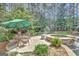 Relaxing outdoor seating area near pool and jacuzzi with stone accents and mature trees at 135 Hayden Ct, Fayetteville, GA 30215