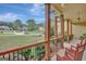 Inviting covered porch featuring wood columns, railings, and rocking chairs with a view of the landscaped front yard at 135 Hayden Ct, Fayetteville, GA 30215