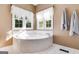 Bright bathroom featuring a corner tiled bathtub and large windows at 333/337 Old Carrollton Rd, Roopville, GA 30170