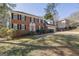 Charming two-story brick home with black shutters, a red door, a manicured lawn, and an attached two-car garage at 2613 Travois Sw Way, Lilburn, GA 30047