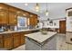 Traditional kitchen with warm wood cabinets, center island, tile backsplash, and black appliances at 2613 Travois Sw Way, Lilburn, GA 30047