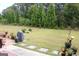 Green backyard with stone pavers, firepit, grill and various shrubs and trees at 2297 Knob Creek Dr, Snellville, GA 30078