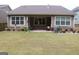 A well-manicured backyard features a covered patio, a large lawn, and lush landscaping at 2297 Knob Creek Dr, Snellville, GA 30078