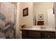 Well-lit bathroom with a wood vanity, framed mirror, and patterned shower curtain at 2297 Knob Creek Dr, Snellville, GA 30078