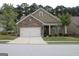 Charming brick home with a two-car garage, manicured lawn, and classic architectural details at 2297 Knob Creek Dr, Snellville, GA 30078