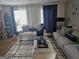 Living room with white walls, white sofas, dark blue accents, and a patterned rug at 6558 Eastbriar Dr, Lithonia, GA 30058