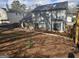 Backyard featuring a gray home with a black roof, bay window, and privacy fence at 6558 Eastbriar Dr, Lithonia, GA 30058