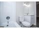 Well-lit bathroom with a white vanity, toilet, and a bathtub with white tile surround at 225 Mertis Ln, Carrollton, GA 30116