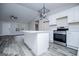 Modern kitchen with white cabinetry, stainless steel appliances, an island, and wood-look flooring at 225 Mertis Ln, Carrollton, GA 30116