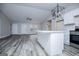 Stylish kitchen island with seating and a view of stainless steel appliances and wood-look flooring at 225 Mertis Ln, Carrollton, GA 30116