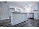 Well-lit kitchen featuring white cabinets, an island with countertop, and stainless steel appliances at 225 Mertis Ln, Carrollton, GA 30116