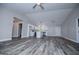 Open living room with wood-look floors flows into kitchen with bright white cabinets and modern pendant lighting at 225 Mertis Ln, Carrollton, GA 30116