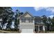 Two-story home with gray siding, dark shutters, and a two-car garage at 140 Tye St, Stockbridge, GA 30281