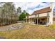 Lush backyard featuring a covered porch, stone patio, and a mature landscape at 270 Sturgess Run, Sharpsburg, GA 30277