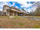Large backyard featuring a covered porch, stone patio, fire pit, and mature trees at 270 Sturgess Run, Sharpsburg, GA 30277