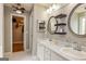 Well-lit bathroom with double sink vanity, decorative mirrors, and walk-in closet at 270 Sturgess Run, Sharpsburg, GA 30277