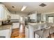 Kitchen featuring bar seating, wooden floors, stainless steel appliances, and white cabinetry at 270 Sturgess Run, Sharpsburg, GA 30277