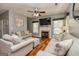 Cozy living room with fireplace, TV, fan, hardwood floor, couches, and natural light at 270 Sturgess Run, Sharpsburg, GA 30277