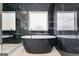 Modern bathroom featuring a black freestanding soaking tub, luxurious tile, and glass enclosed shower at 859 N Bay Overlook, Villa Rica, GA 30180