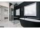 Elegant bathroom featuring a soaking tub, glass-enclosed shower, marble tile, and a view of the walk-in closet at 859 N Bay Overlook, Villa Rica, GA 30180