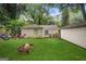 A grassy backyard featuring a fire pit, shed, brick home, and a blue-doored deck at 1273 Boulevard Lorraine Sw, Atlanta, GA 30311