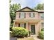 Cozy two-story brick townhome with a covered front porch and lush green bushes at 1406 Bayrose Cir # 6B, East Point, GA 30344