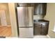 Stainless steel refrigerator stands adjacent to dark wood cabinets in this kitchen with an additional counter area at 1406 Bayrose Cir # 6B, East Point, GA 30344