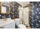 The bathroom features bold wallpaper, a vanity with gold fixtures, and a shower with decorative glass at 123 Stratmore Pl, Stockbridge, GA 30281
