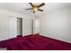 Bedroom with one window, red carpet, a ceiling fan with lighting, closet and white walls at 123 Stratmore Pl, Stockbridge, GA 30281
