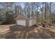 Detached garage with brick facade and single car door nestled among trees on the property at 123 Stratmore Pl, Stockbridge, GA 30281