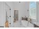 Bright bathroom features a soaking tub, walk-in shower with marble tile, and a window for natural light at 930 Laurel Brooke Ave, Peachtree City, GA 30269