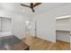 Bright bedroom features hardwood floors, ceiling fan, walk-in closet, and staircase access at 930 Laurel Brooke Ave, Peachtree City, GA 30269