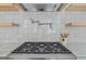 This kitchen features stainless steel range hood, pot filler, decorative backsplash, and wooden shelving at 930 Laurel Brooke Ave, Peachtree City, GA 30269