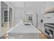 Modern kitchen with stainless steel appliances, a large marble countertop island, and access to the porch at 930 Laurel Brooke Ave, Peachtree City, GA 30269