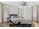 Sunlit primary bedroom with hardwood floors, elegant curtains, and a stylish ceiling fan at 930 Laurel Brooke Ave, Peachtree City, GA 30269