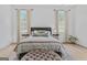 Light-filled bedroom with hardwood floors, stylish curtains, and a comfortable bed with tufted ottoman at 930 Laurel Brooke Ave, Peachtree City, GA 30269