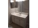 Bathroom featuring a white vanity, sink, mirror, light fixture, and neutral colored floor tiles at 4111 Pine Heights Ne Dr, Atlanta, GA 30324