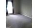 Spacious bedroom with neutral walls and carpet, complemented by window and curtains at 4111 Pine Heights Ne Dr, Atlanta, GA 30324
