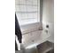 Inviting white bathtub with tile surround and window for natural light at 11714 Double Lake Xing, Fayetteville, GA 30215