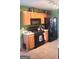 Functional kitchen with black appliances, wooden cabinets, and bright green walls at 11714 Double Lake Xing, Fayetteville, GA 30215