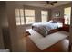 A cozy bedroom features a ceiling fan, wood floors, two windows, and a stylish, comfortable bed with decorative pillows at 47 Elm St, Hampton, GA 30228
