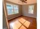 Bright bedroom featuring hardwood floors, a ceiling fan, and multiple windows for ample natural light at 47 Elm St, Hampton, GA 30228