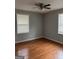 Cozy bedroom with hardwood floors, ample natural light from windows with blinds, and neutral gray paint at 47 Elm St, Hampton, GA 30228