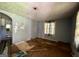 Empty living room with peeling paint, damaged floors, and debris, showing its state of disrepair at 47 Elm St, Hampton, GA 30228