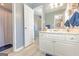 Well-lit bathroom featuring a white vanity, spacious mirror, and an open doorway to the shower at 245 Longshore Way, Fayetteville, GA 30215