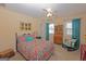 Cozy bedroom featuring colorful bedding, vintage furniture, bright windows, and a ceiling fan at 245 Longshore Way, Fayetteville, GA 30215