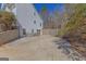 View of a concrete driveway leading to an attached garage with a partial view of a two-story house at 245 Longshore Way, Fayetteville, GA 30215