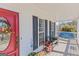 Cozy front porch with a red door, benches, and hanging swing creating a relaxing outdoor space at 245 Longshore Way, Fayetteville, GA 30215
