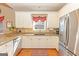 Bright and airy kitchen featuring white cabinets, stainless steel appliances, and granite countertops at 245 Longshore Way, Fayetteville, GA 30215