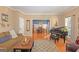 Comfortable living room with a brown couch, a baby grand piano, and an adjacent dining room at 245 Longshore Way, Fayetteville, GA 30215